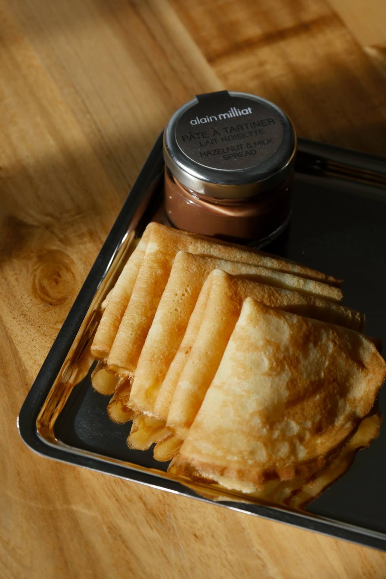 Mini crêpes pliées sur un plateau en inox, avec un pot de pâte à tartiner Alain Milliat