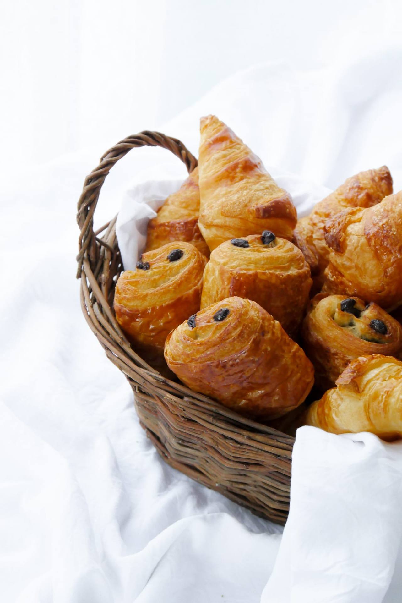 Panier en osier garni de croissants et pains au chocolat