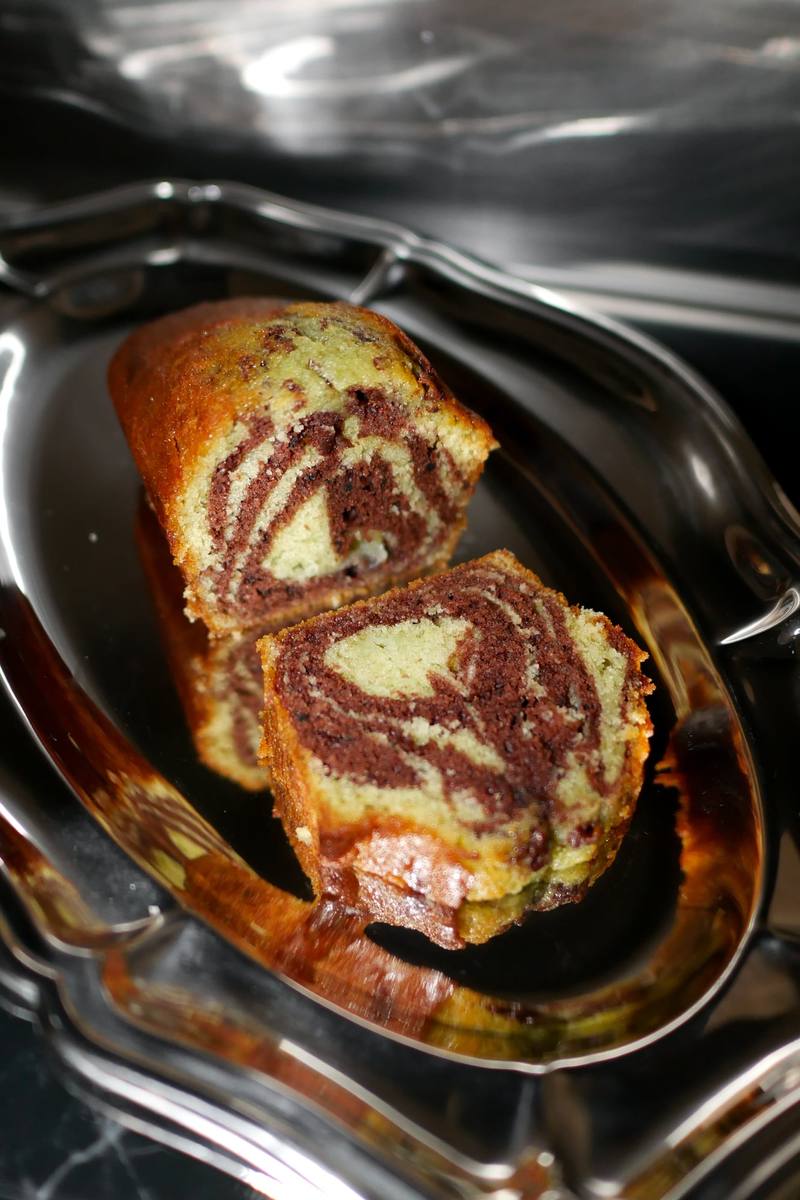 Tranches de cake marbré pistache et chocolat sur un plat en métal argenté